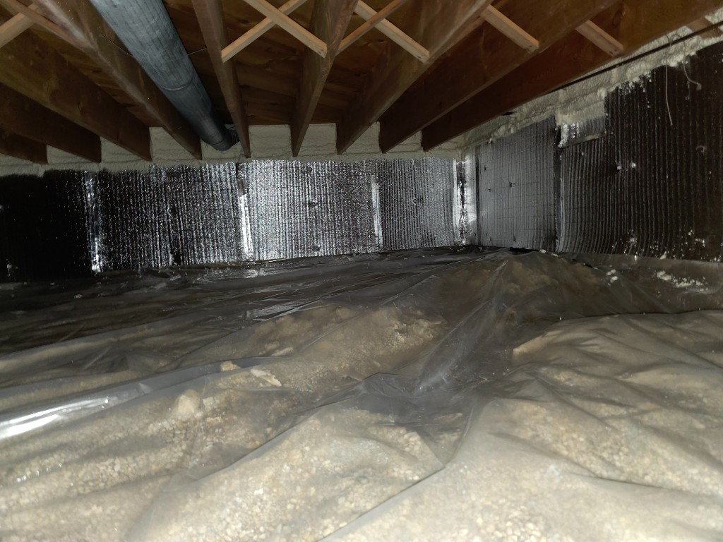 Crawlspace with reflective wall insulation, spray foam at rim joists, and sealed vapor barrier over the floor