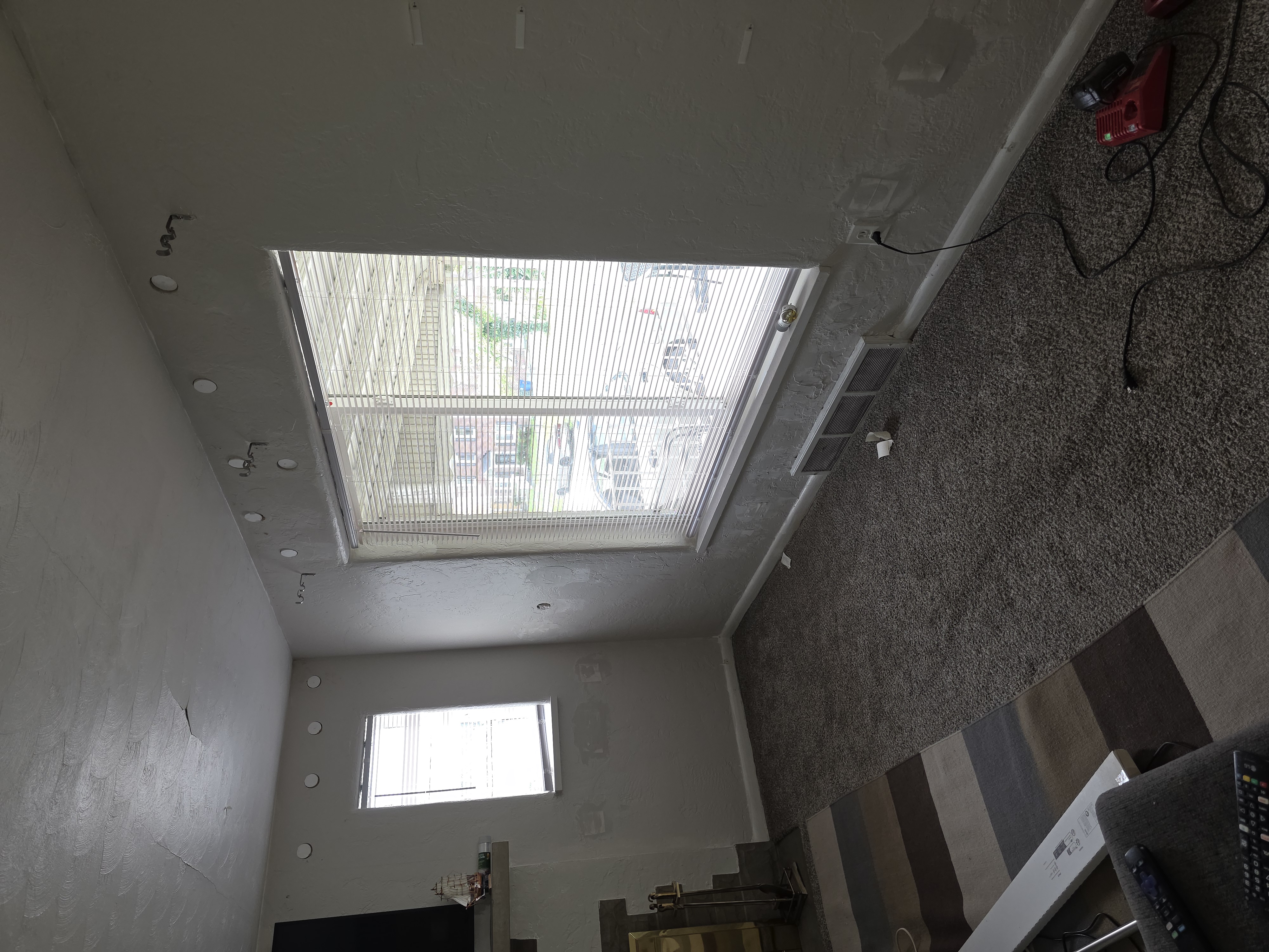 Living room with patched drill holes near the ceiling after exterior wall cavities were filled from inside
